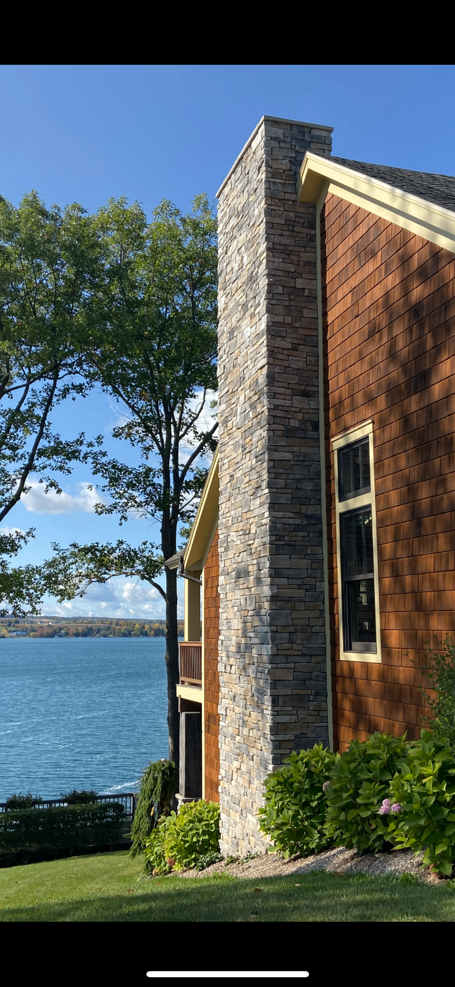 Lakeside residence with natural stone chimney and cladding